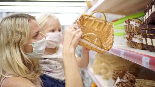 Familie, vrouw en kind in medische maskers in de winkel kiezen goederen — Stockvideo