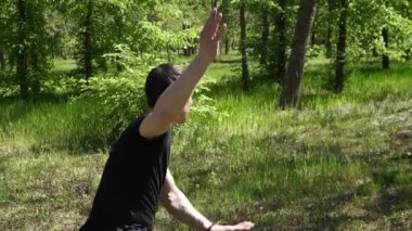 Doğu dövüş sanatları ustası parkta eğitim görüyor. Dövüş sanatlarının erkek eğitmeni.