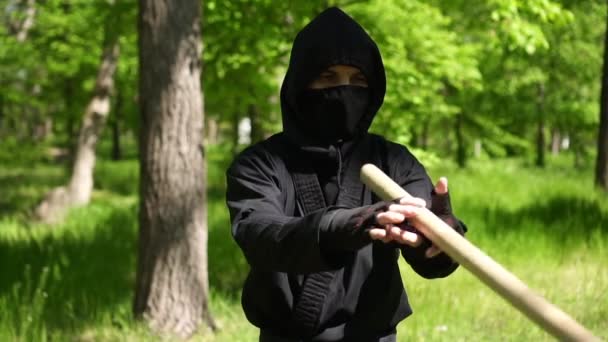 Retrato de un hombre ninja. Japonés ninja en un negro traje es la formación en la naturaleza — Vídeo de stock