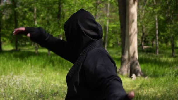 Portret van een ninja in een zwart pak, slow motion. Ninja is aan het trainen in vechtsport — Stockvideo