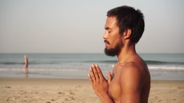 A pessoa está envolvida na meditação na natureza. Um homem está meditando na praia — Vídeo de Stock