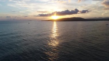 Denizin üzerinde gün batımı, güneş ışınları, yatlar. Güzel akşam ışığı arkaplanı