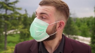 Erkek bir işadamı tıbbi maskesini çıkarır ve derin bir nefes alır.