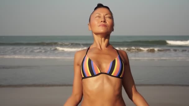 Uma mulher bonita pratica ioga ao ar livre. Menina asiática está praticando ioga — Vídeo de Stock