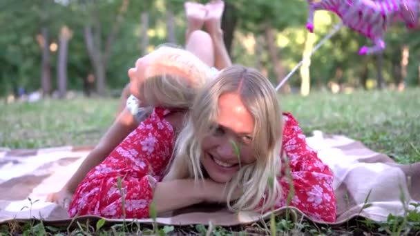 Verano, feliz madre joven y la hija del bebé se relajan en el parque al aire libre — Vídeo de stock