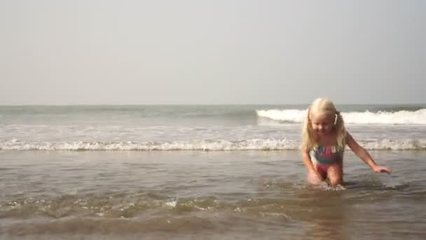 Kind meisje spelen op het strand en zwemmen in de zee bij de kust — Stockvideo