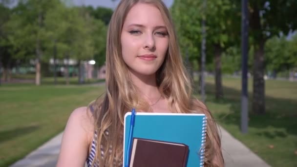 Studentessa con quaderno e libro nel parco. Studente donna all'aperto — Video Stock