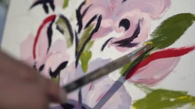 Sanatçı tuval üzerinde fırçayla resim yapar, vuruşlar yapar, yakın plan