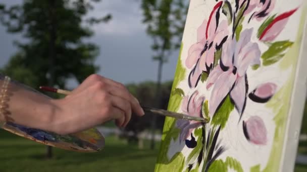 Artista pinta un cuadro con un pincel sobre lienzo al aire libre. Artista chica — Vídeos de Stock