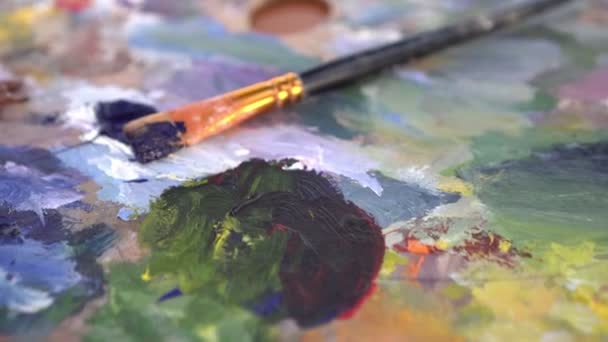 Brosse et palette multicolore en bois brillant avec peintures pour peinture — Video