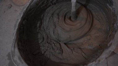 Yapı tutkalı kovaya karıştırılır. Onarım, karıştırma, fayans yapıştırıcısı.