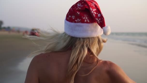 Tarde, una persona celebra la Navidad o Año Nuevo junto al mar en la playa . — Vídeos de Stock