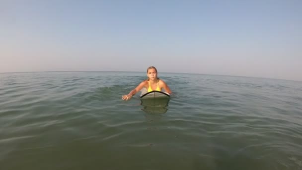 Piękna dziewczyna surfuje. Kobieta unosi się na desce surfingowej. Surfing w Goa — Wideo stockowe