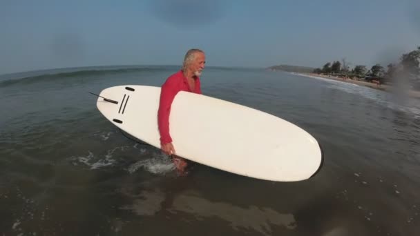 Stary, zdrowy człowiek surfujący. Aktywne życie na emeryturze. Dziadek sportu — Wideo stockowe