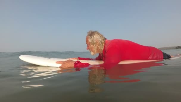 Nyugdíjas nagyapa megtanul szörfözni. Az öregember sportolni megy.. — Stock videók
