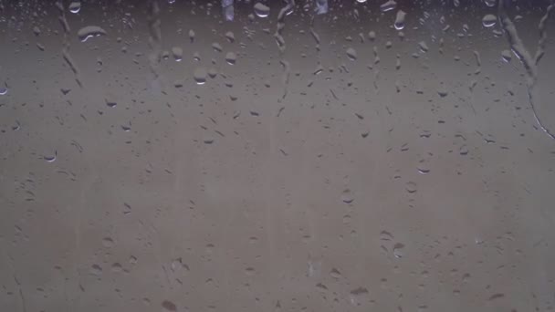 Raindrops on gray glass. Autumn, rain is falling outside the window. — Stock Video