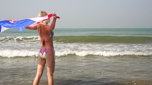 Schöne sexy Mädchen mit der Flagge von Island auf dem Hintergrund des Meeres, Zeitlupe — Stockvideo