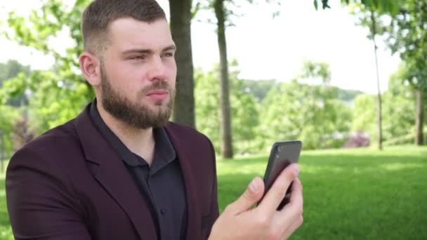 Hombre de negocios o gerente al aire libre hace una videollamada utilizando un teléfono inteligente — Vídeo de stock