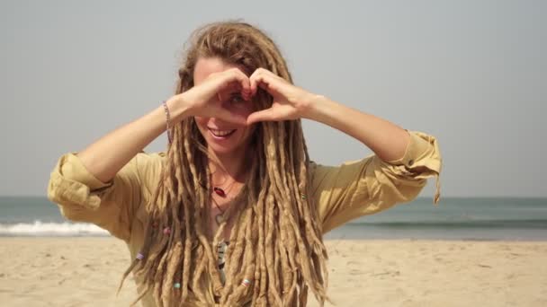 Çekici hippi kadın kalp şeklinde parmaklarıyla aşk işareti gösteriyor.. — Stok video