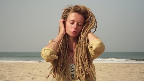 年轻迷人的嬉皮士女人，在沙滩上炎热的一天，留着可怕的头发 — 图库视频影像