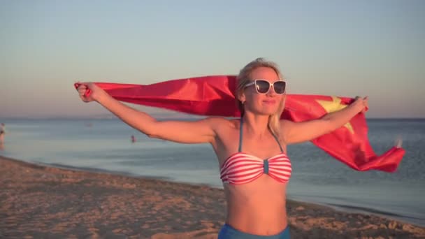 아름다운 여성이 중국 국기를 해변에 걸고 있습니다. 수영복을 입고 중국 국기를 든 소녀 — 비디오