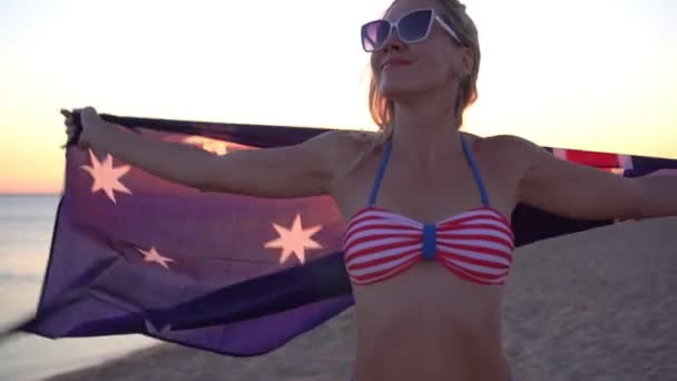 Mujer con la bandera de Australia en la playa del mar. Chica en traje de baño con la bandera de Australia — Vídeos de Stock