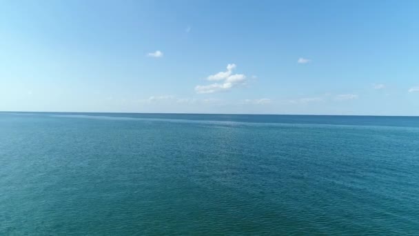 Belo fundo marinho, vista aérea. Ondulações na superfície do mar e nuvens brancas no céu azul — Vídeo de Stock