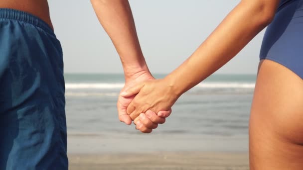 Young couple in love man and woman hold hands on the background of the sea — Stock Video
