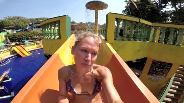 Triste femme ennuyée conduit lentement sur la glissière d'eau dans le parc aquatique — Video