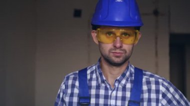 Elektrikli tornavidayla genç ve çekici bir erkek inşaatçının portresi.