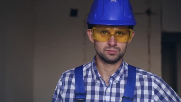 Retrato de un joven constructor masculino atractivo con un destornillador eléctrico — Vídeos de Stock