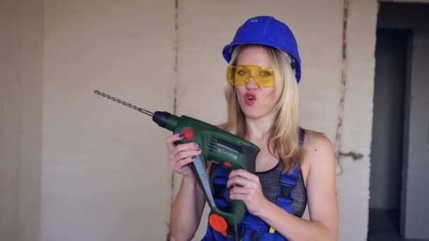 Trabalhadora de construção feminina positiva com um perfurador elétrico. Construtor de loira — Vídeo de Stock