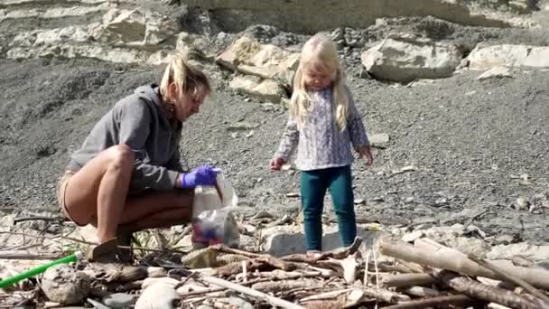 Mensen verwijderen afval uit de natuur en reinigen de aarde van plastic en menselijk afval — Stockvideo