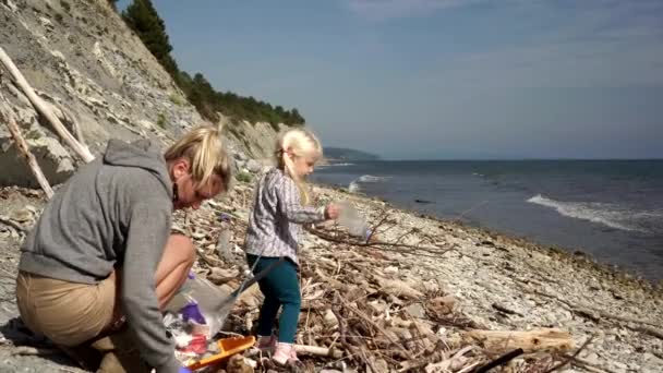 Mensen ruimen afval op en reinigen het strand van plastic en menselijk afval. — Stockvideo