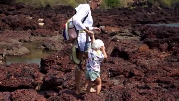 Una mujer y un niño viajan juntos y caminan a lo largo de la costa salvaje — Vídeos de Stock