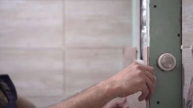 Erkek bir inşaat işçisi seramik fayansları duvara yapıştırır ve onarır.