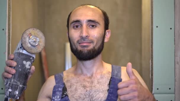 An adult male worker or construction worker in overalls shows a thumbs up — Stock Video