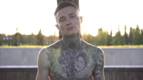 Jovem homem atraente com corpo tatuado, braços e pescoço ao ar livre — Vídeo de Stock