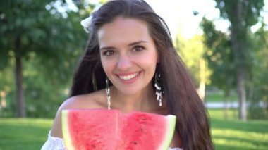 Dışarıda kırmızı karpuz taşıyan güzel bir kadının portresi.