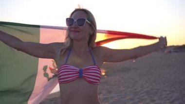 Meksika bayrağı taşıyan çekici genç bayan turist kumlu sahilde