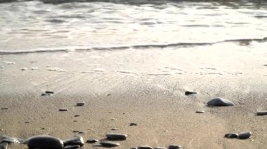 Küçük taşları ve deniz dalgaları olan kumsal. Güzel deniz arka planı, okyanusta sörf.