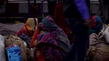 Agra, Hindistan, Ocak 2020. Hindistan 'da bir tren istasyonunda fakir insanlar yerde oturup tren bekliyor..