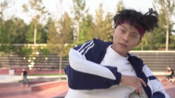 Молодой азиатский подросток танцует брейк-данс на улице — стоковое видео