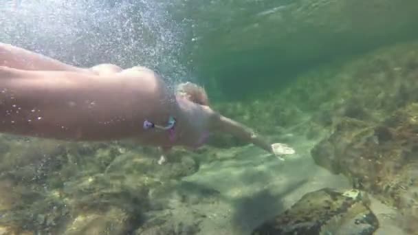 Спортивная стройная женщина в купальнике плавает под водой на дне моря — стоковое видео