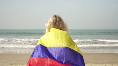 Kolombiya bayraklı tropikal plajda bir kadın.