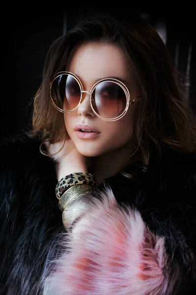 Kapalı gözlüklü güzel bir modelin portresi. Moda gözlükleri, modern moda tarzı, yumuşak bej renkler. 