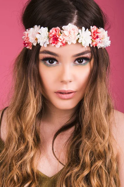 Genç bir kadının portresi, uzun saçlı, modern makyajlı güzel bir genç kız portresi, pembe arka planda izole edilmiş bir moda, pastel renk düzeni.