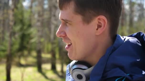 Un joven se dedica a los deportes en la naturaleza. Mañana caminando al aire libre en el Parque . — Vídeos de Stock