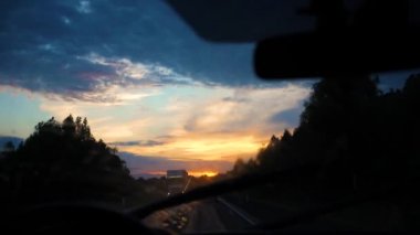 Aile gezisi. Aile otobanda arabayla gider. Gece yol, gün batımı