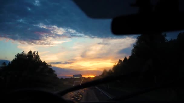 Viaje familiar. La familia va en coche por la carretera. Camino nocturno, puesta de sol — Vídeo de stock